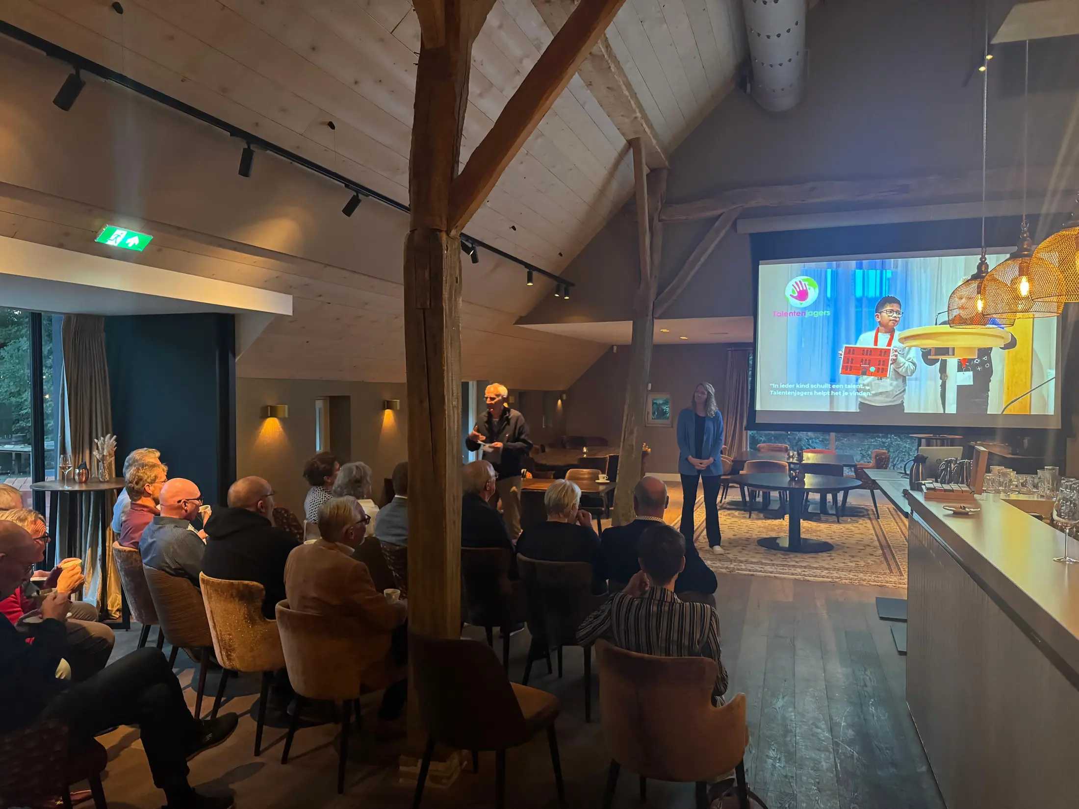 Talentenjagers Hoogeveen presenteert het programma aan een zaal met genodigden